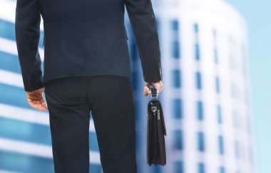 İşadamı ile evrak çantası el üzerinde bina arka plan bulanık. Avukat ve noter kavramı.