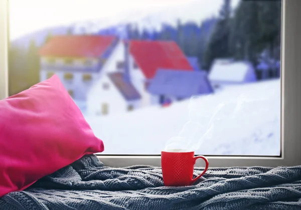 Cup of hot drink on the windowsill in winter landscape background — Stock fotografie