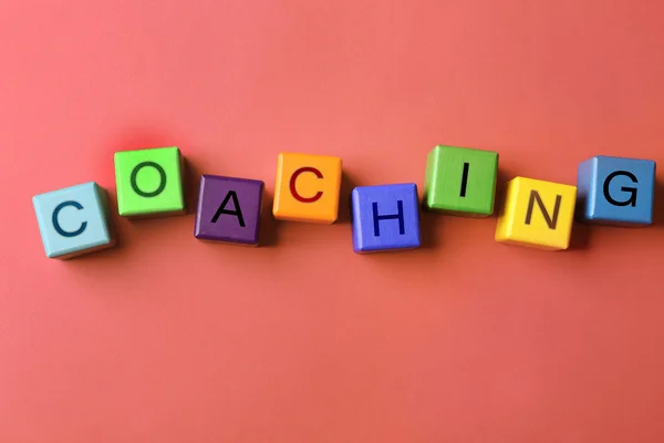 Coaching-Konzept. Holzwürfel auf rosa Hintergrund — Stockfoto
