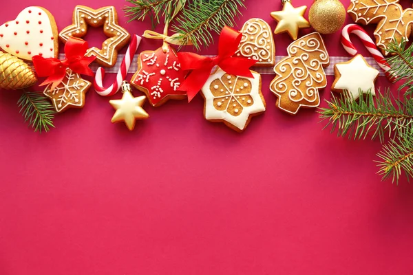 Savoureux biscuits au pain d'épice et décor de Noël sur fond de couleur — Photo