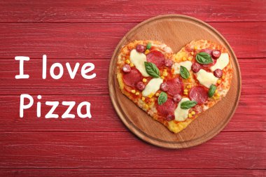 Ahşap arka plan üzerinde kalp şeklinde pizzayla plaka