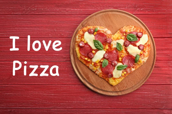 Ahşap arka plan üzerinde kalp şeklinde pizzayla plaka