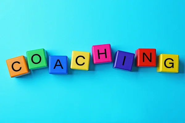 Coaching concept. Wooden cubes on blue background — Stock Photo, Image