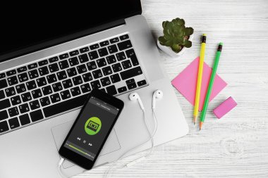 Dizüstü bilgisayar, kulaklık ve bir tablo üzerinde cep telefonu