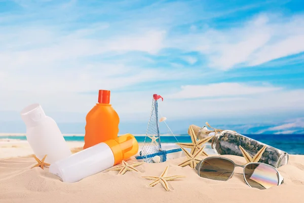 Accessori per abbronzatura su spiaggia su sfondo mare e cielo — Foto Stock