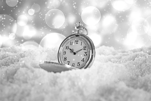 Vintage pocket watch on snow against blurred background. Christmas concept. — ストック写真