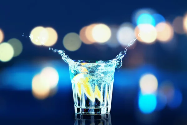 Cocktail colorato con spruzzi su sfondo luci — Foto Stock