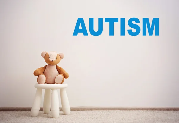 Dzieci Autyzm koncepcja. Stołek dzieci z zabawkami na tle białej ściany — Zdjęcie stockowe