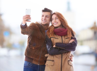 Genç mutlu çift selfie alarak şehir sokak arka plan bulanık