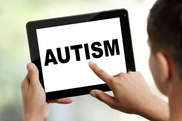 Концепція дитячого аутизму. Молодий чоловік з планшетом на розмитому фоні — стокове фото