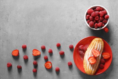 Lezzetli pasta ve gri arka plan üzerinde meyveleri ile plaka