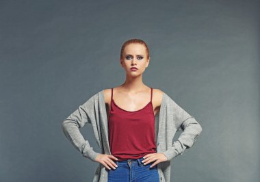 Gri arka plan karşı rahat kıyafetler içinde genç ve güzel sarışın kadın