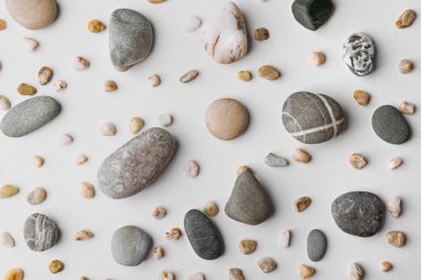 Scattering of big and small pebbles on white background clipart