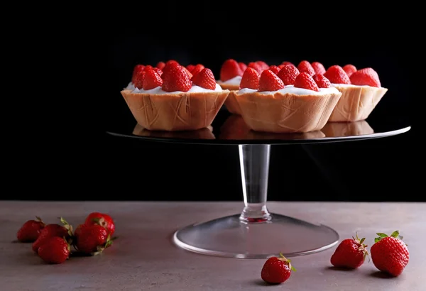 Leckere Kuchen mit Erdbeeren am Glasstand — Stockfoto