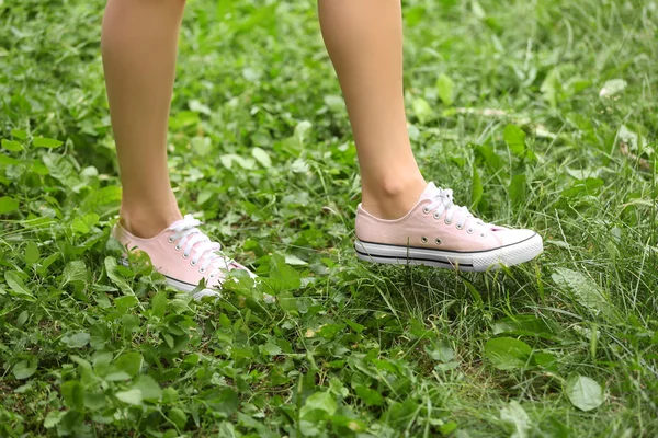 Yeşil çimenlerin üzerinde kadın bacakları — Stok fotoğraf