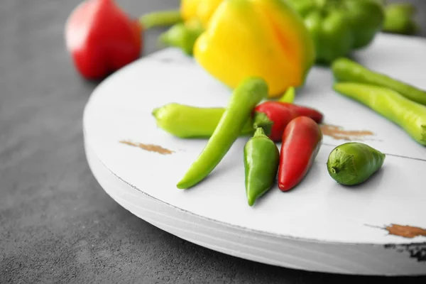 Diferentes tipos de pimenta na bandeja de madeira — Fotografia de Stock