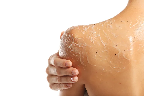 Mujer joven aplicando exfoliante en hombro sobre fondo blanco —  Fotos de Stock