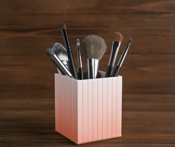 Set of makeup brushes in decorative box on wooden background — Stock fotografie