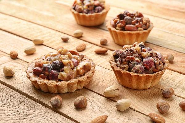 Delicious nut cakes on wooden table — Stock Photo, Image