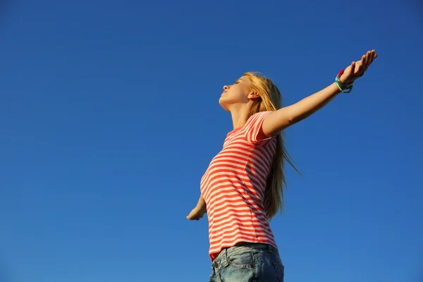Boldog, fiatal nő, a kék ég háttér — Stock Fotó
