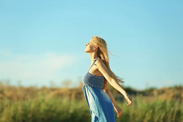 Felice giovane donna su sfondo cielo blu — Foto Stock