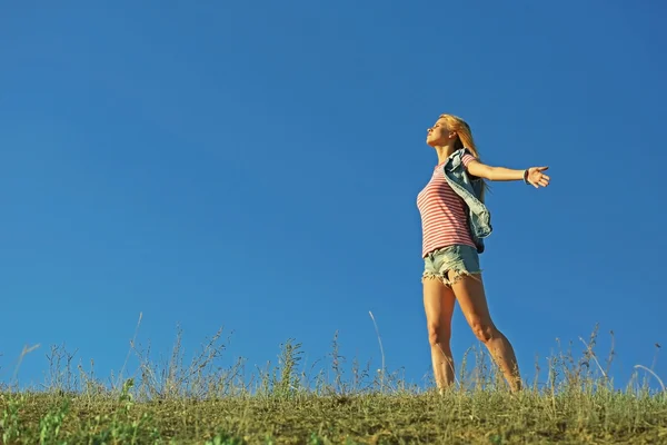 Счастливая молодая женщина на голубом фоне неба — стоковое фото