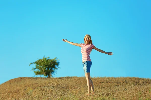 Glad ung kvinna på blå himmel bakgrund — Stockfoto