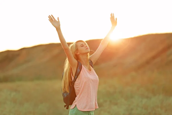 Ung kvinna med att höja händerna på blå himmel bakgrund — Stockfoto