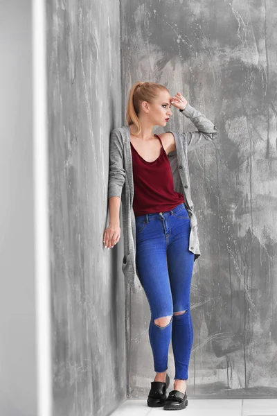 Mooie jonge blonde vrouw in casual kleding tegen grunge achtergrond — Stockfoto