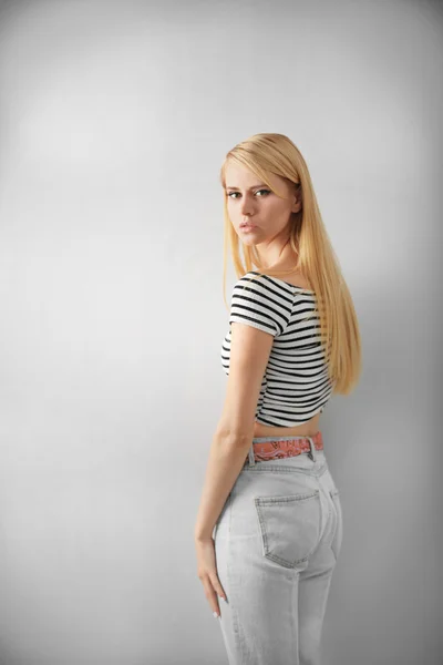 Csinos, fiatal nő alkalmi ruhák-ra könnyű háttér — Stock Fotó