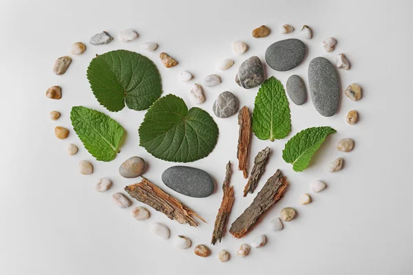 Heart made of leaves, pebbles and pieces of bark isolated on white — Stock Photo, Image