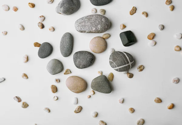 Scattering of big and small pebbles on white background — Stock Photo, Image