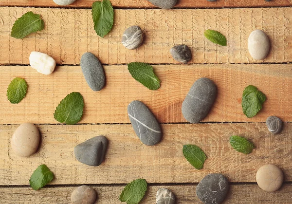 Scattering of leaves and pebbles on wooden background — Stock Photo, Image