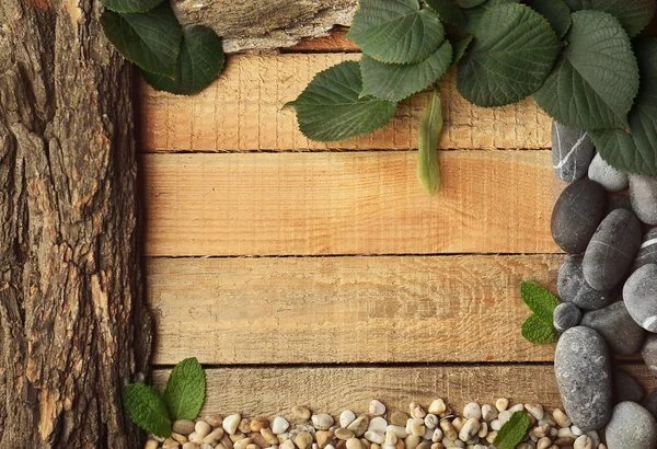 Rechteckiger Rahmen aus Blättern, Kieseln und Rinde auf Holzgrund — Stockfoto