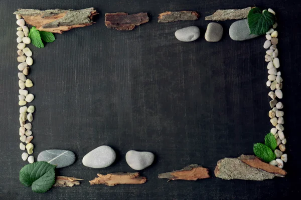 Rectangular frame made of leaves, pebbles and bark on dark background — Stock Photo, Image