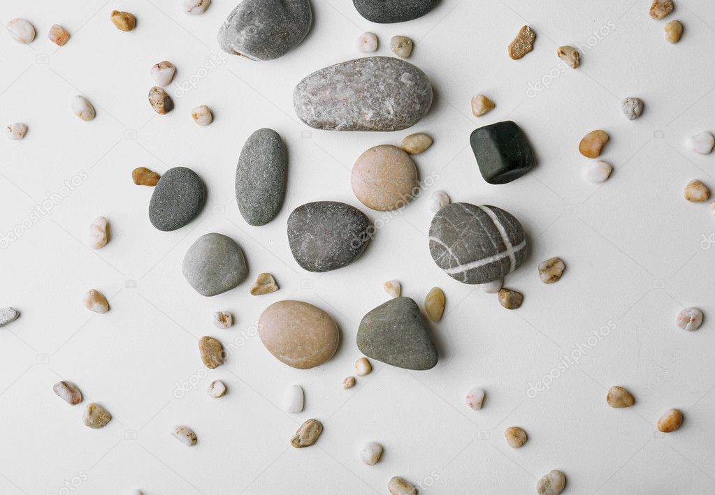Scattering of big and small pebbles on white background