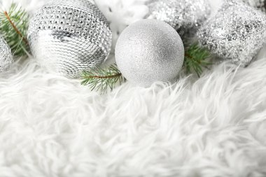 Güzel Noel baubles ve iğne yapraklı dallar üzerinde beyaz kürk görünümünü kapat