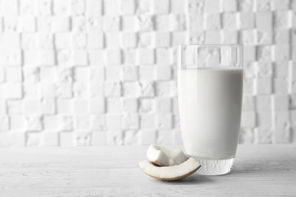 白い背景をぼかした写真に対して木製テーブルの上おいしいココナッツ ミルクのガラス — ストック写真