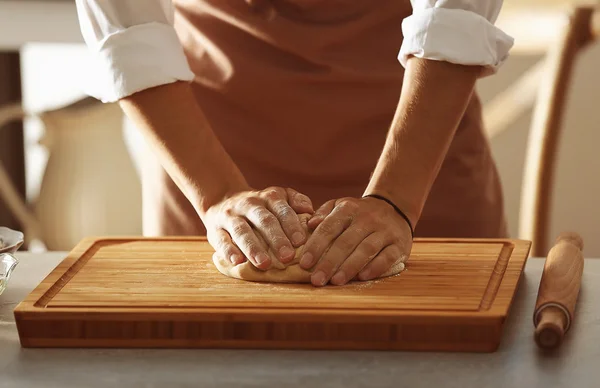 Tangan laki-laki membuat adonan di atas meja dapur — Stok Foto