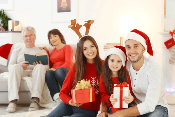 Happy family with Christmas presents in living room — Stock Photo, Image