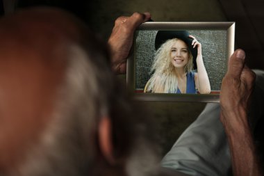 Yaşlı adam genç kadın, mutlu anılar kavramı resim ile fotoğraf çerçevesi holding