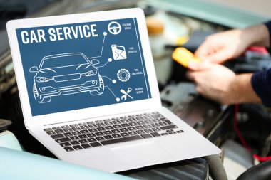 Dizüstü bilgisayar araba motoru yakınındaki. Modern araba tanılama programı üstünde perde. Araba hizmet anlayışı.