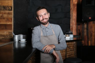 ahşap bar counter yakınındaki gülümseyen barmen