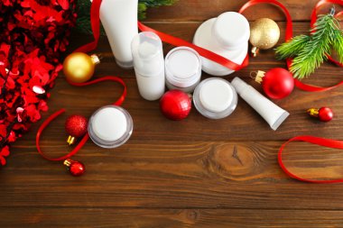 Ahşap arka plan üzerinde Noel dekorasyonu ile güzellik kozmetik ürünleri