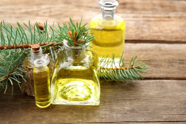 Şişe kozalaklı uçucu yağ ve ahşap arka plan, dalda görünümü kapatın