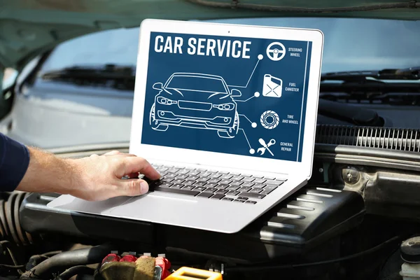 Meccanico con computer portatile vicino motore auto. Moderno programma di diagnostica auto sullo schermo. concetto di servizio auto . — Foto Stock