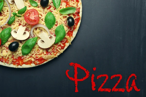 RAW pizza z warzywami i słowo Pizza na ciemnym tle. — Zdjęcie stockowe