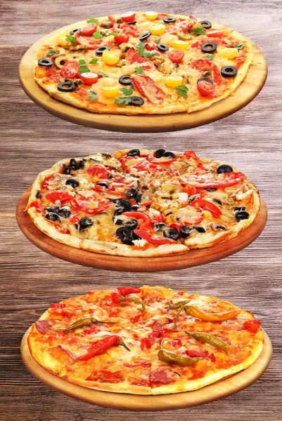 Sada lahodné pizzy na dřevěné pozadí. — Stock fotografie