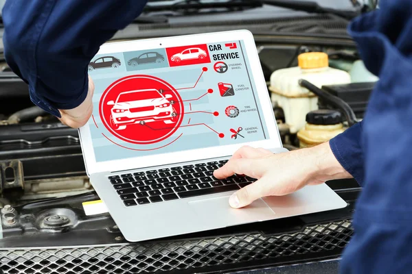 Monteur met laptop in de buurt van automotoren. Moderne auto diagnoseprogramma op scherm. Auto dienstverleningsconcept. — Stockfoto