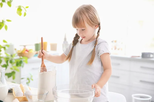 Little girl in kitchen making dough — Stock Photo, Image